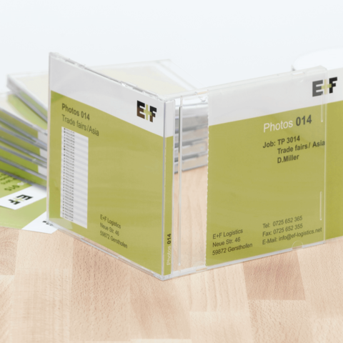 Ordner mit Fotos, beschriftet "Photos 014" und "Job: TP 3014", zeigt Informationen zu Messen in Asien und enthält Kontaktdaten.